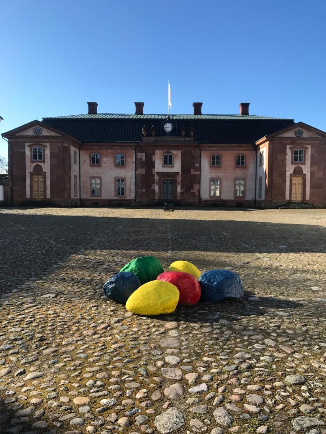 Stora färgglada påskägg på kullerstensborggården framför Övedsklosters huvudbyggnad