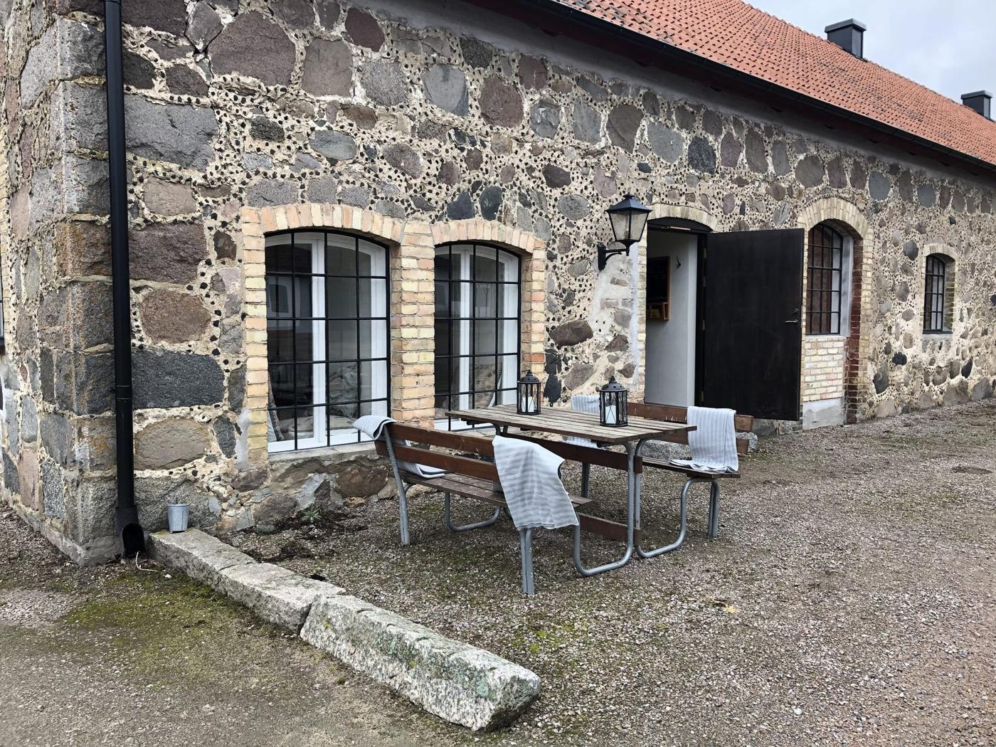 Stenstallets stenfasad med tegeltak vid Övedskloster