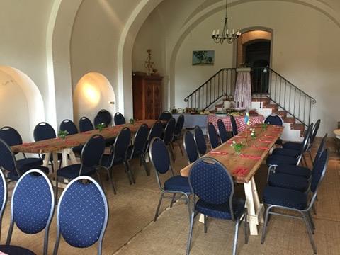 Trädgårdsvalvet med valvklätt tak, dukade långbord och blå stolar